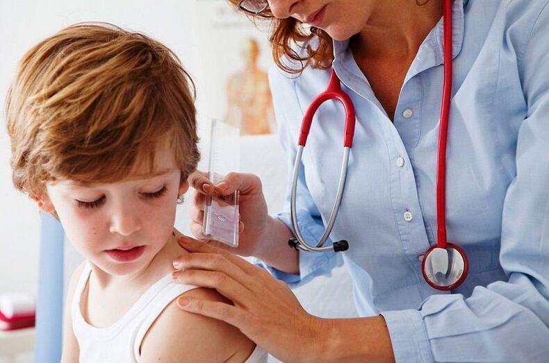 arts onderzoekt een kind met papilloma op het lichaam